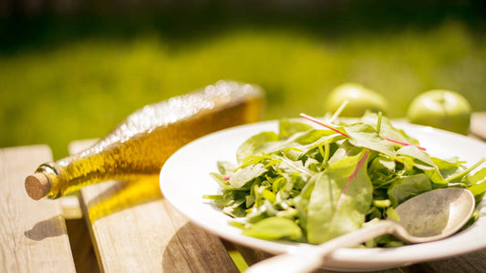 Plat de salade accompagné du bouteille d'huile d'olive
