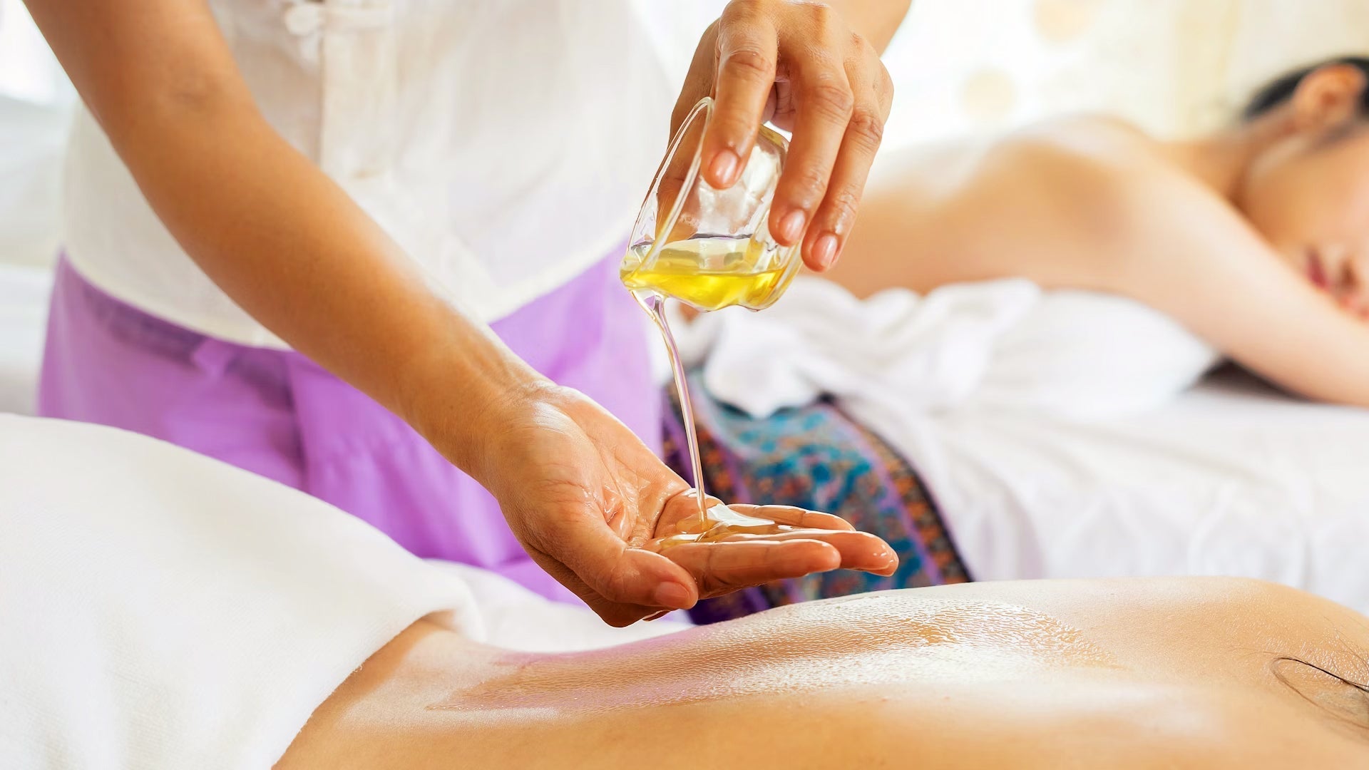 Femme se faisant masser le dos avec de l'huile
