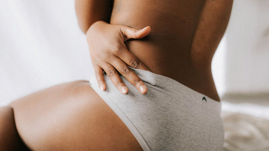 Femme se tenant le ventre en culotte menstruelle