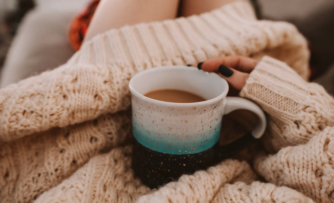 Image d'une femme en pull en laine tenant un tasse de café