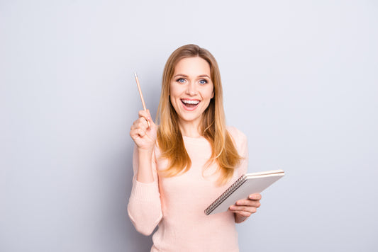 femme tenant un carnet de notes et stylo